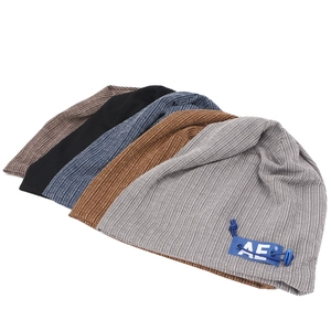 Macro shot of knitted beanies with vertical ribbed texture and AE letter woven label