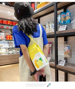 Creative yellow lemonade carton crossbody bag with lemon patterns worn by a model