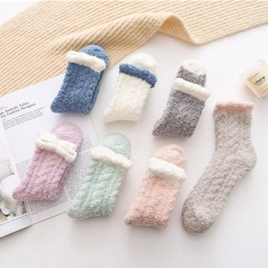 Close-up of thick coral fleece socks in pastel colors with cozy home lifestyle decor