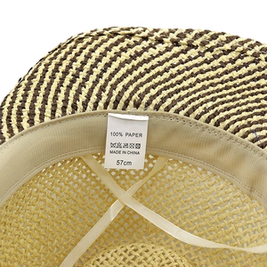 Detail view of the 100% paper straw hat interior label showing size and material