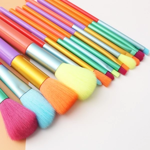 Colorful 15-piece watercolor makeup brush set with metallic handles on neutral background