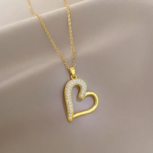 Detailed close-up of a heart pendant necklace featuring half-pave zircons on gold chain