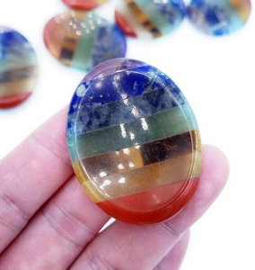 Detailed close-up of a polished 7 chakra worry stone held in hand for meditation
