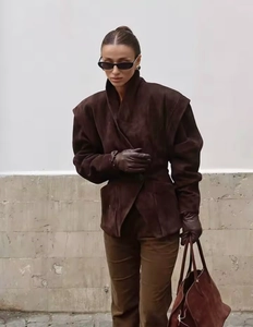 Detail view of premium dark brown suede blazer jacket featuring a deep V-neck and matte texture