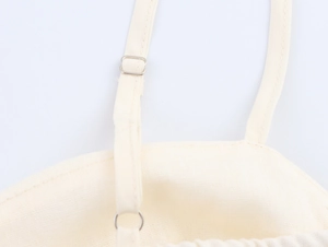 Detail of adjustable shoulder strap and metal buckle on beige cotton linen dress set