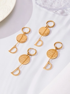 Détail des boucles d'oreilles plaquées or 18 carats avec pendentif D et breloques rondes