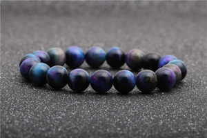 Macro detail of natural tiger eye beads bracelet with blue and purple gradient cat eye effect