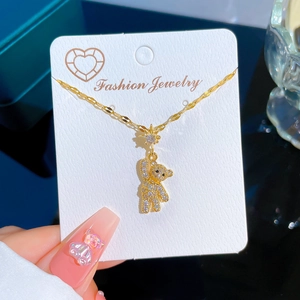 Titanium steel gold necklace featuring a sparkling crystal bear pendant on display card