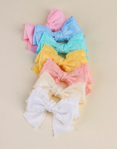 Vue détaillée de nœuds à cheveux en tissu plissé aux couleurs pastel et texture fine
