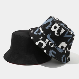 Detail view of double-sided bucket hats in plain black and blue graffiti print canvas