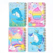 Spiral notebooks featuring colorful silicone pop-it sensory toys in various cartoon designs