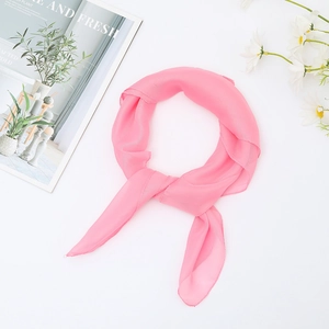 Pink chiffon square scarf 65x65cm tied on a minimalist background with fresh daisies