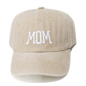 Detailed view of white MOM embroidery on beige washed cotton baseball cap with eyelets
