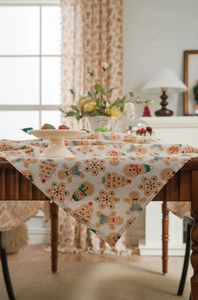 Close-up of linen tablecloth featuring Christmas gingerbread man and tree pattern