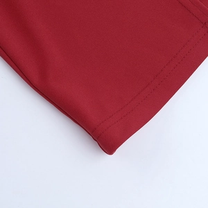 Detailed close-up of red satin fabric with double-stitched seams and twill texture