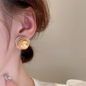 Gros plan d'une boucle d'oreille perle vintage avec base croissant dorée et strass