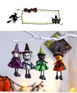 Detail of four Halloween plush dolls including a witch and ghost hanging on white branches