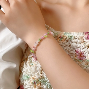 Detail of handmade beaded flower bracelet with pink and green floral patterns