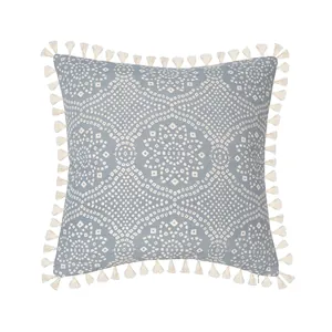 Detailed macro view of woven fabric texture and ivory tassels on mandala cushion cover