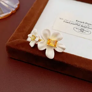 Elegant gold plated double flower ring with yellow zircons on a brown velvet stand