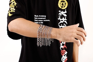 Various sizes of silver stainless steel curb links displayed on a model's arm