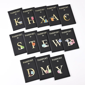 Detail of black passport holders featuring gold foil lettering and travel illustrations