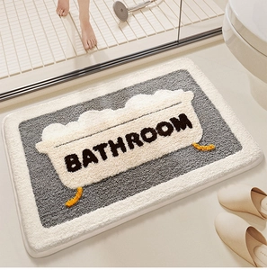 Detail of gray plush bathroom mat with non-slip texture and woven BATHROOM lettering
