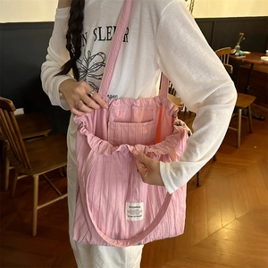 Detail of pink pleated tote bag interior showing large capacity and internal pocket