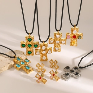 Cross pendant necklaces and earrings with colorful stones on natural rock texture