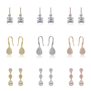 Detailed close-up of geometric drop earrings in silver, gold, and rose gold finishes