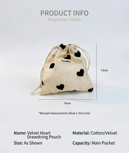 Close-up of champagne heart drawstring pouch showing 16x14cm size and brand tag