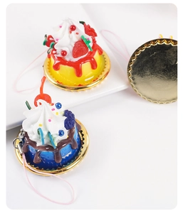 Detailed view of artificial strawberry and berry cream cake models on gold coasters