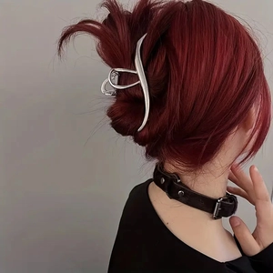 Détail de la pince à cheveux en métal argenté portée sur les cheveux pour un chignon chic