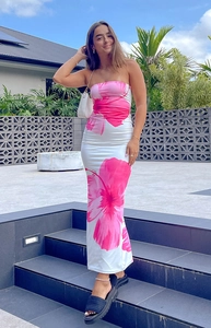 Detail of white strapless maxi dress featuring vibrant pink floral print and slim fit cut