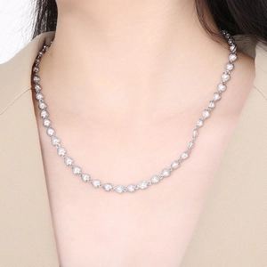 Close-up of a silver heart-shaped link chain necklace worn on a fashion model neckline