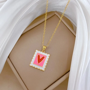Macro shot of gold square stamp pendant necklace with red heart in luxury jewelry box