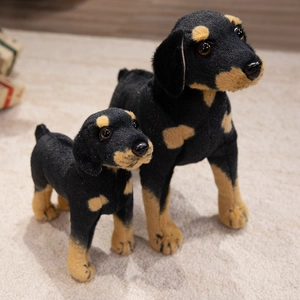 Realistic black and brown plush Rottweiler dog stuffed toy set on a soft rug