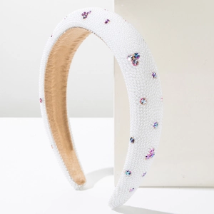 Close-up of padded white sponge headband with faux pearls and colorful crystals