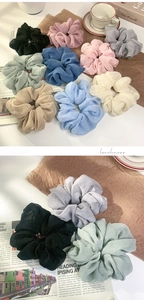 Detailed view of assorted silk oversized hair scrunchies with pleated texture and elastic band