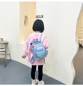 Kids blue sequin heart backpack with cute wings shown on a young girl model