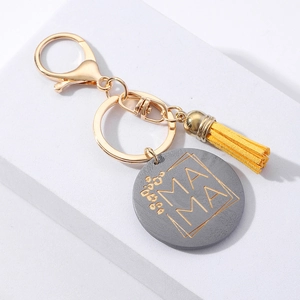 Fashionable MAMA keychain with yellow tassel and gray round charm on display stand