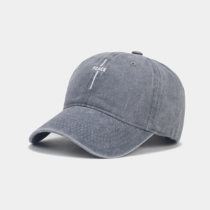 Detailed view of white PEACE embroidery on vintage washed cotton baseball cap