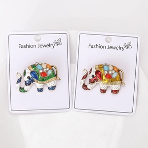 Detailed close-up of elephant enamel brooches with colorful rhinestones on display card