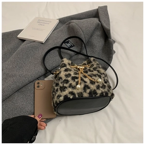 Detail of leopard print bucket bag with gold chain and pearls on a grey wool coat