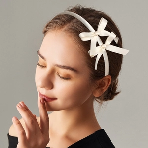 White satin double bow headband for girls featuring a minimalist ballet style hair accessory