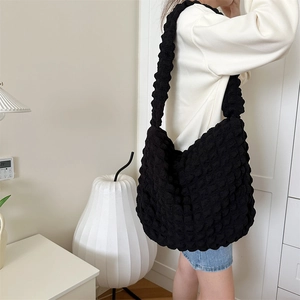 Detail of black popcorn textured tote bag showing large capacity and soft bubble fabric