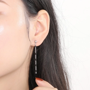Detail of silver long tassel earrings with black beads worn by a model in profile