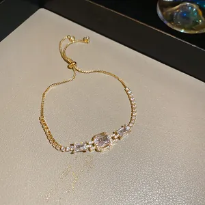 Macro detail of luxury adjustable 18K gold bracelet featuring three emerald cut zircons