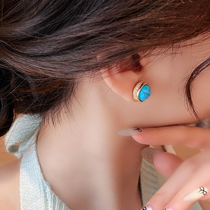 Detail shot of vintage round turquoise stud earrings with gold plating on model