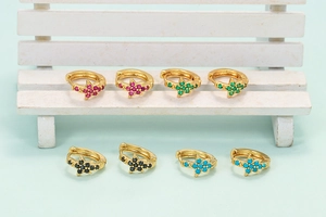 Close-up of gold star hoop earrings set with red, green, black and blue zircon stones